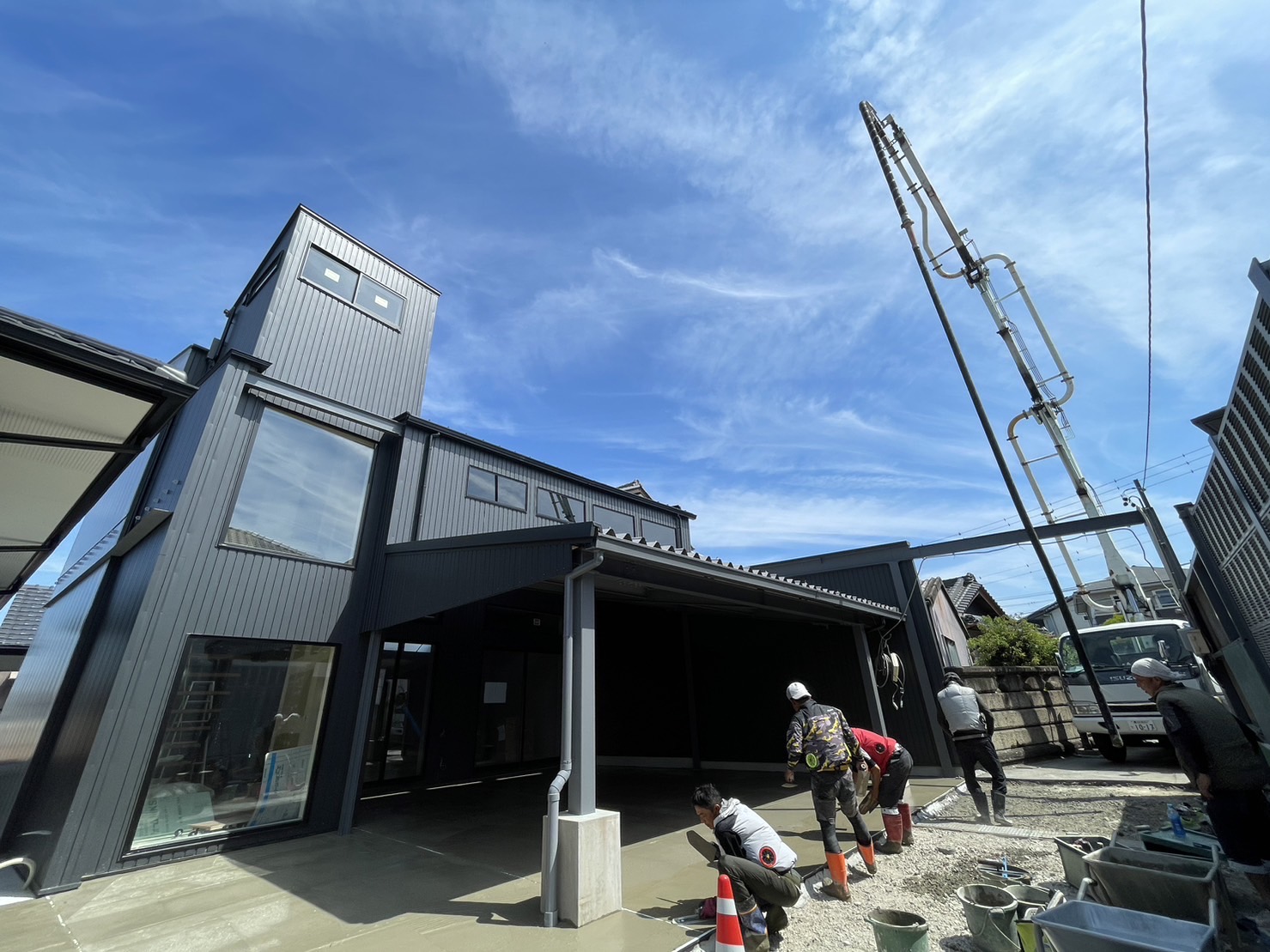 建物前でコンクリートをならしている工事中の様子